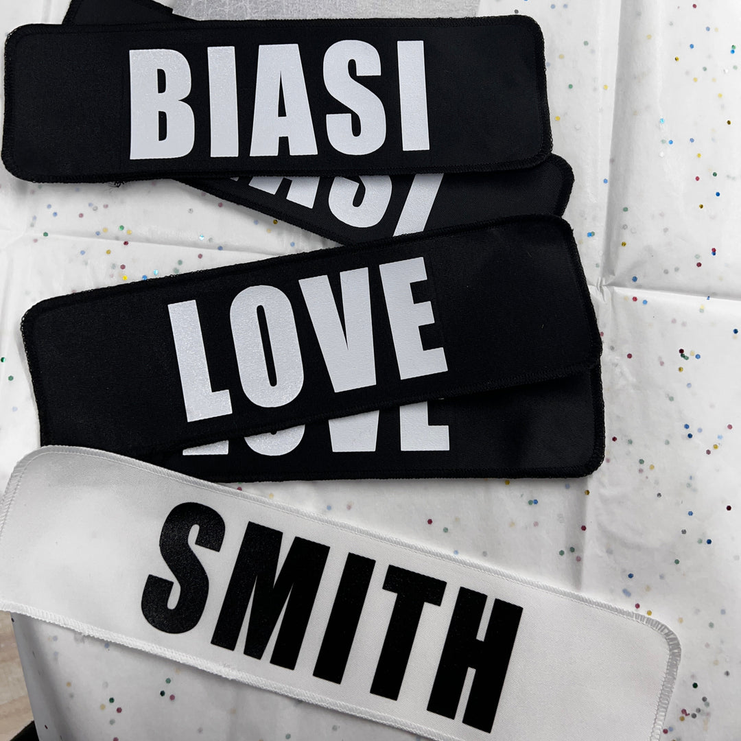 A collection of name bars with 'BIAS LOVE' text in black, white, and gray, displayed on a surface with a white jersey featuring a similar design.
